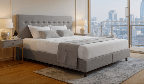 Modernes Schlafzimmer mit grauem Polsterbett und ergonomischer Matratze, große Fenster mit Stadtblick